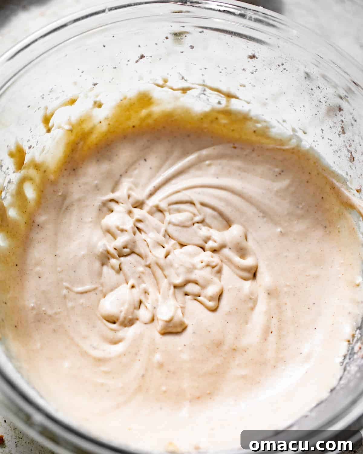 Smooth apple glaze being whisked in a bowl, ready to drizzle.
