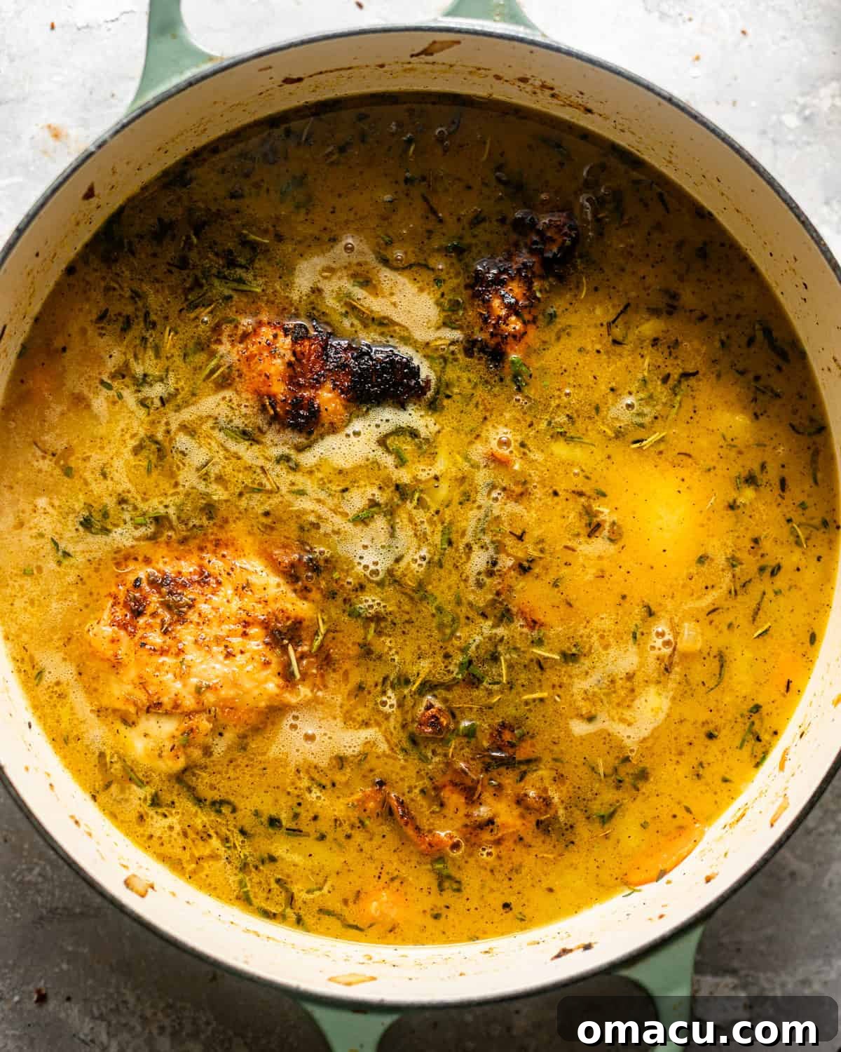 cooked vegetables, chicken thighs, and chicken broth in a large pot. 