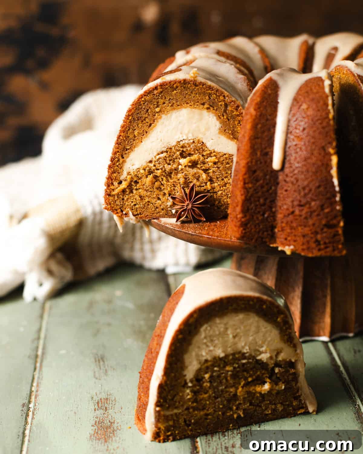 A close-up view of a slice of pumpkin pound cake, showcasing the distinct creamy cheesecake swirl within its moist, golden-brown crumb.