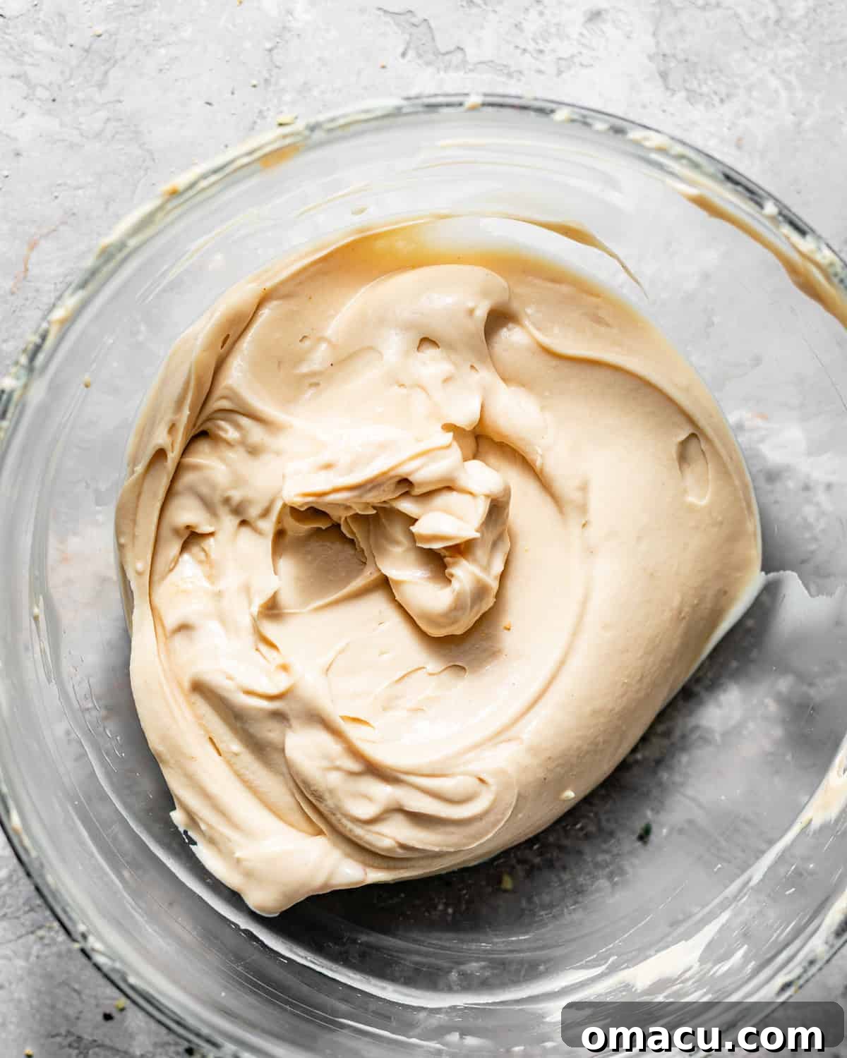 Creamy white cream cheese filling perfectly mixed in a bowl, smooth and ready for the pumpkin pound cake.