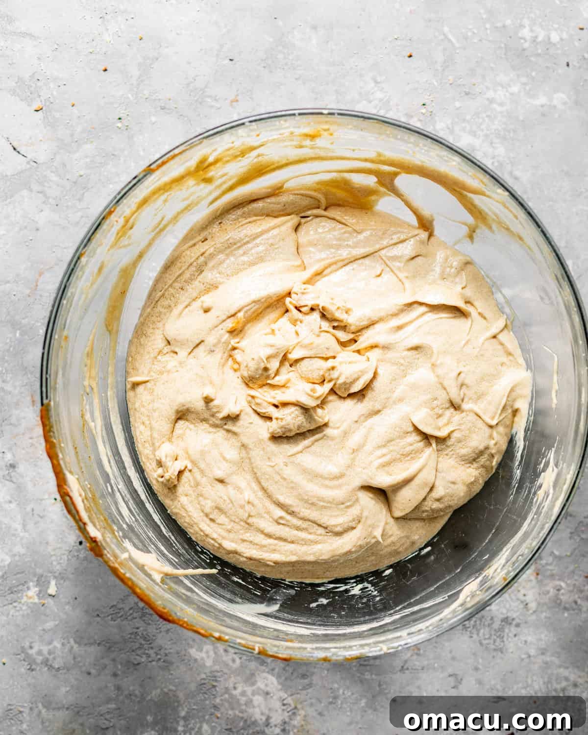 Close-up of butter, vegetable oil, and both brown and white sugars creamed together in a stand mixer bowl, light and fluffy.
