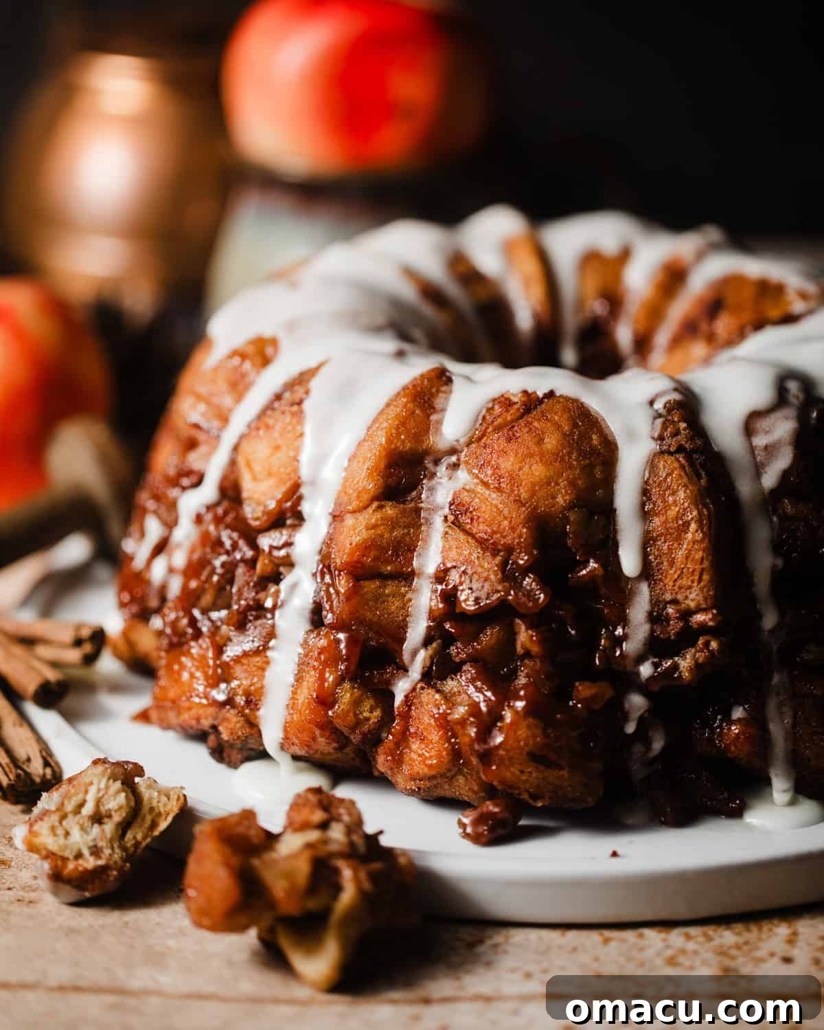 apple monkey bread on a plate covered in icing.