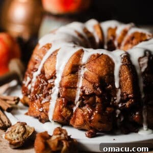 apple monkey bread on a plate covered in icing.