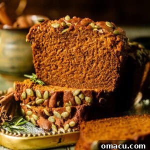 Sliced Starbucks copycat pumpkin bread on a gold plate with cinnamon sticks and rosemary.