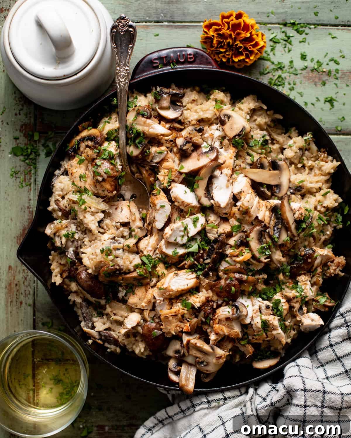 creamy mushroom chicken and rice in a skillet topped with fresh parsley.