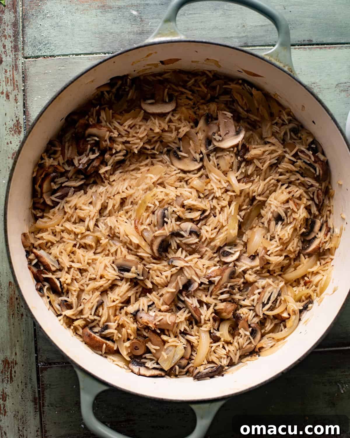 mushrooms, onions, garlic, seasonings, and rice in a pan with wine and chicken broth. 