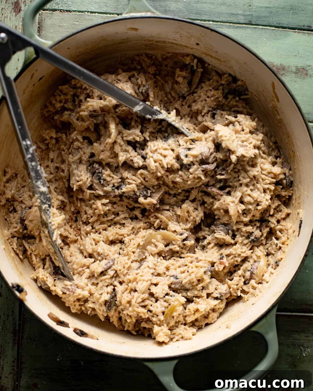 cooked rice in a pot with cream and parmesan cheese.