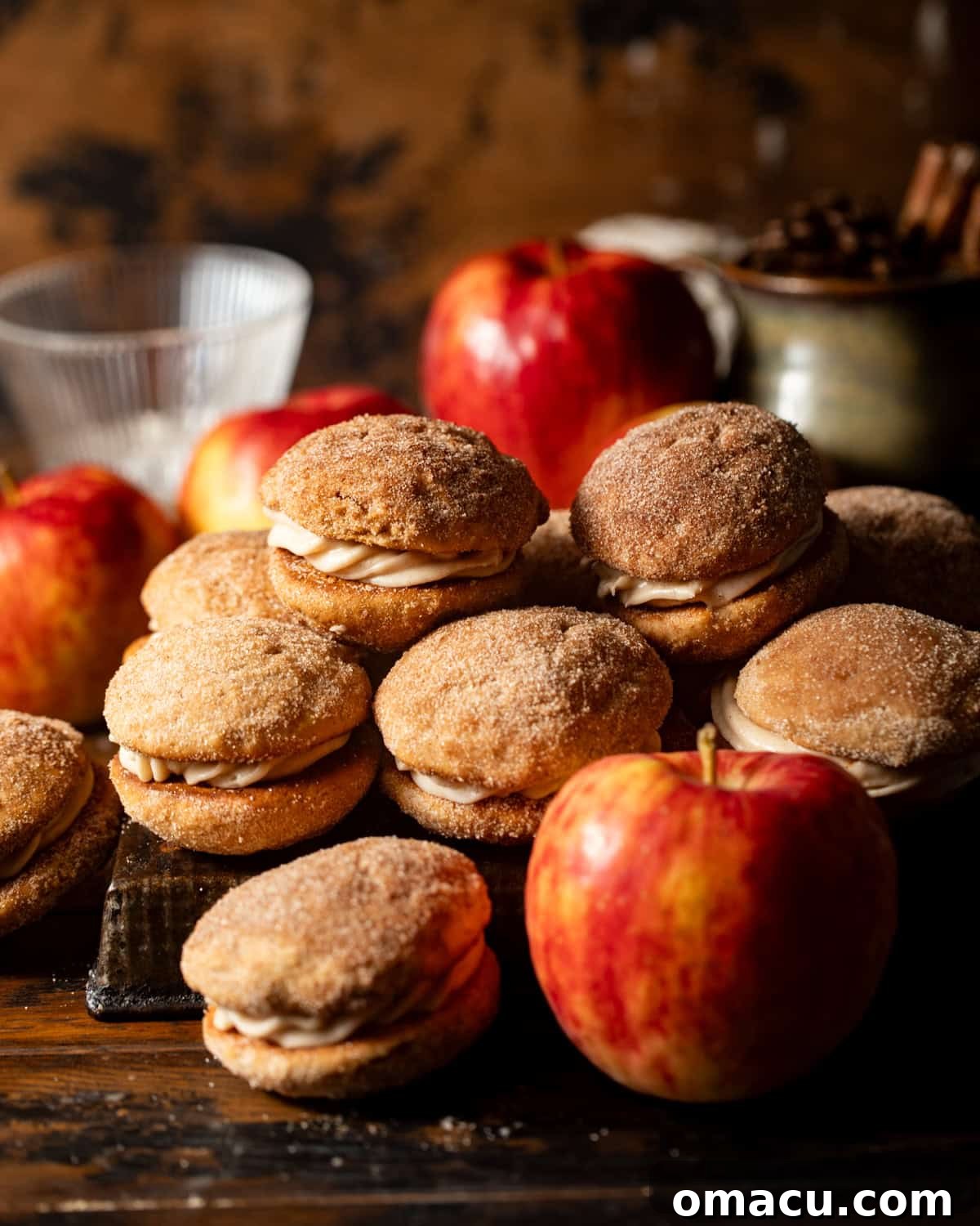 apple cider whoopie pies stacked on top of each other on a table. 