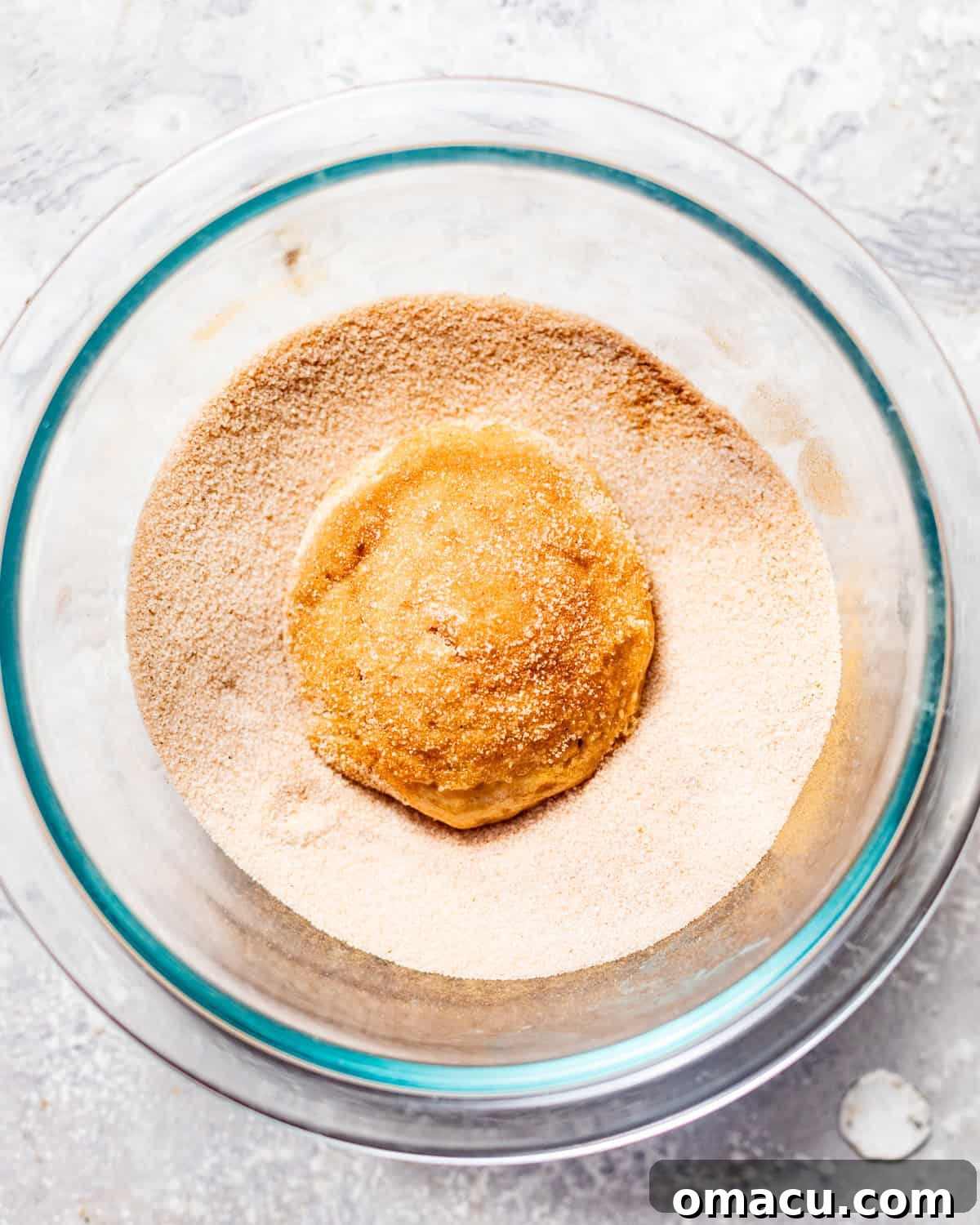 whoopie pies in a bowl of cinnamon sugar.