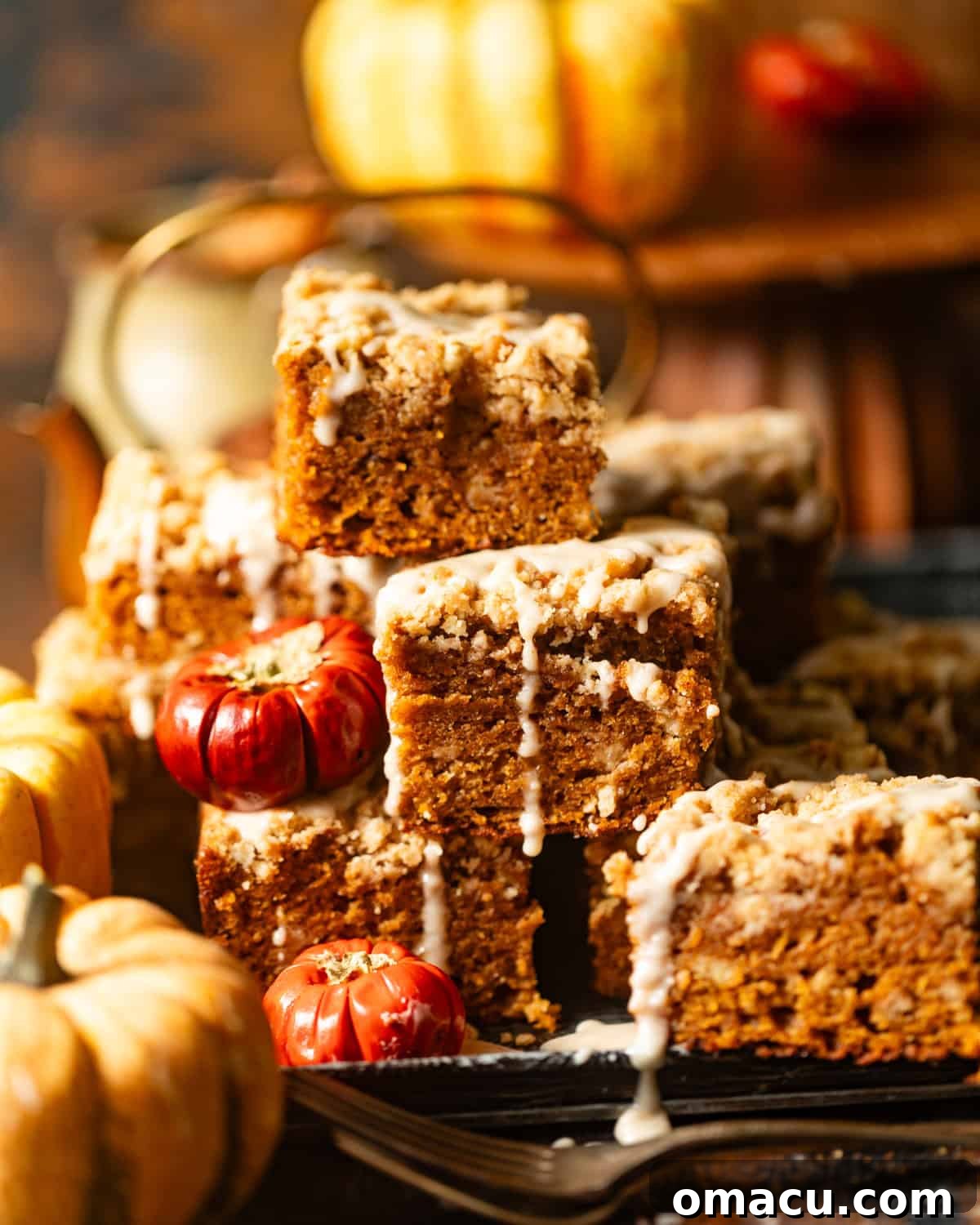 sliced pumpkin coffee cake stacked up on each other covered in brown butter maple glaze.
