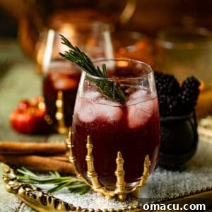 Witches Brew cocktail in a skeleton glass with a sprig of rosemary to garnish.