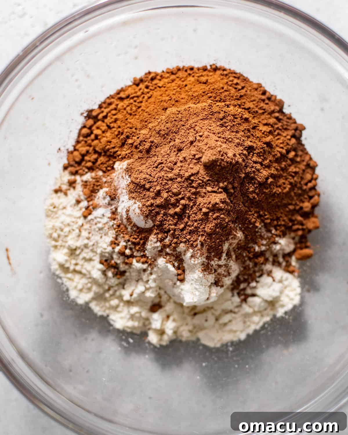 All dry ingredients for the chocolate espresso cake, including cake flour, Dutch-processed cocoa powder, instant espresso powder, baking powder, baking soda, and kosher salt, are carefully whisked together in a separate bowl.