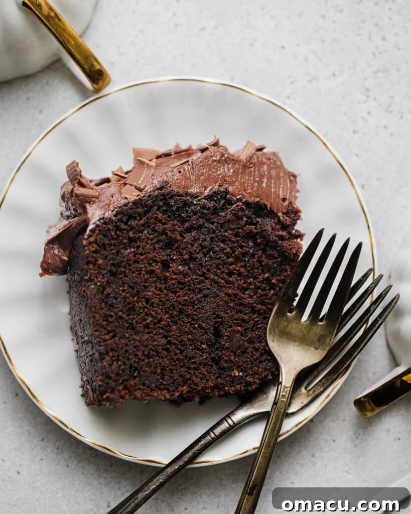 A decadent slice of chocolate espresso cake, artfully arranged on a pristine white plate, accompanied by two elegant forks, inviting indulgence.
