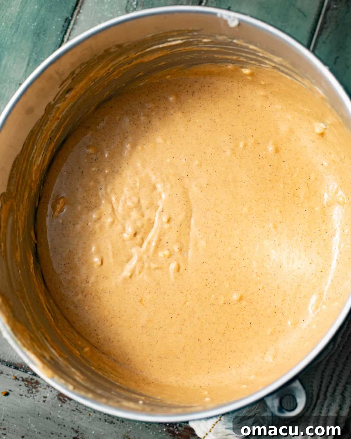 pumpkin cheesecake batter mixed together in the bowl of a stand mixer.