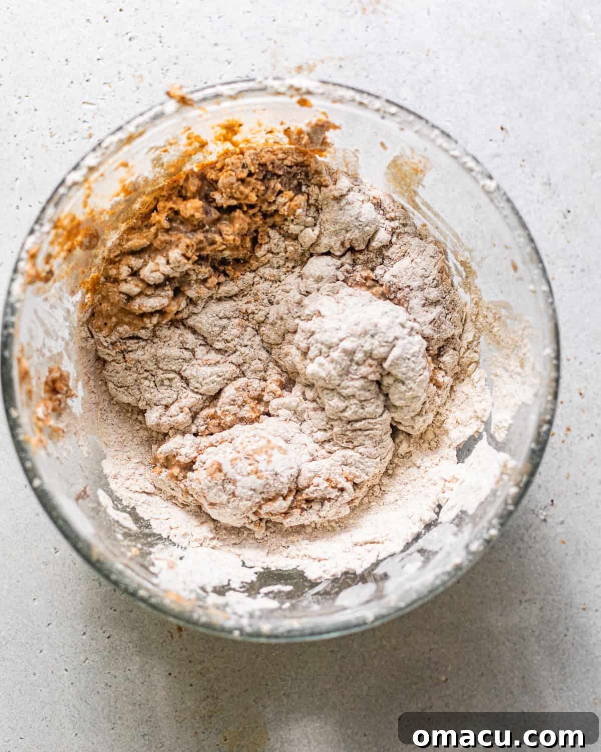 Cube steaks thoroughly coated in a seasoned flour mixture, forming a thick, craggy breading ready for frying.
