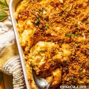 Twice baked mashed potatoes in a baking dish topped with crispy breadcrumbs, bacon bits, and fresh chives.
