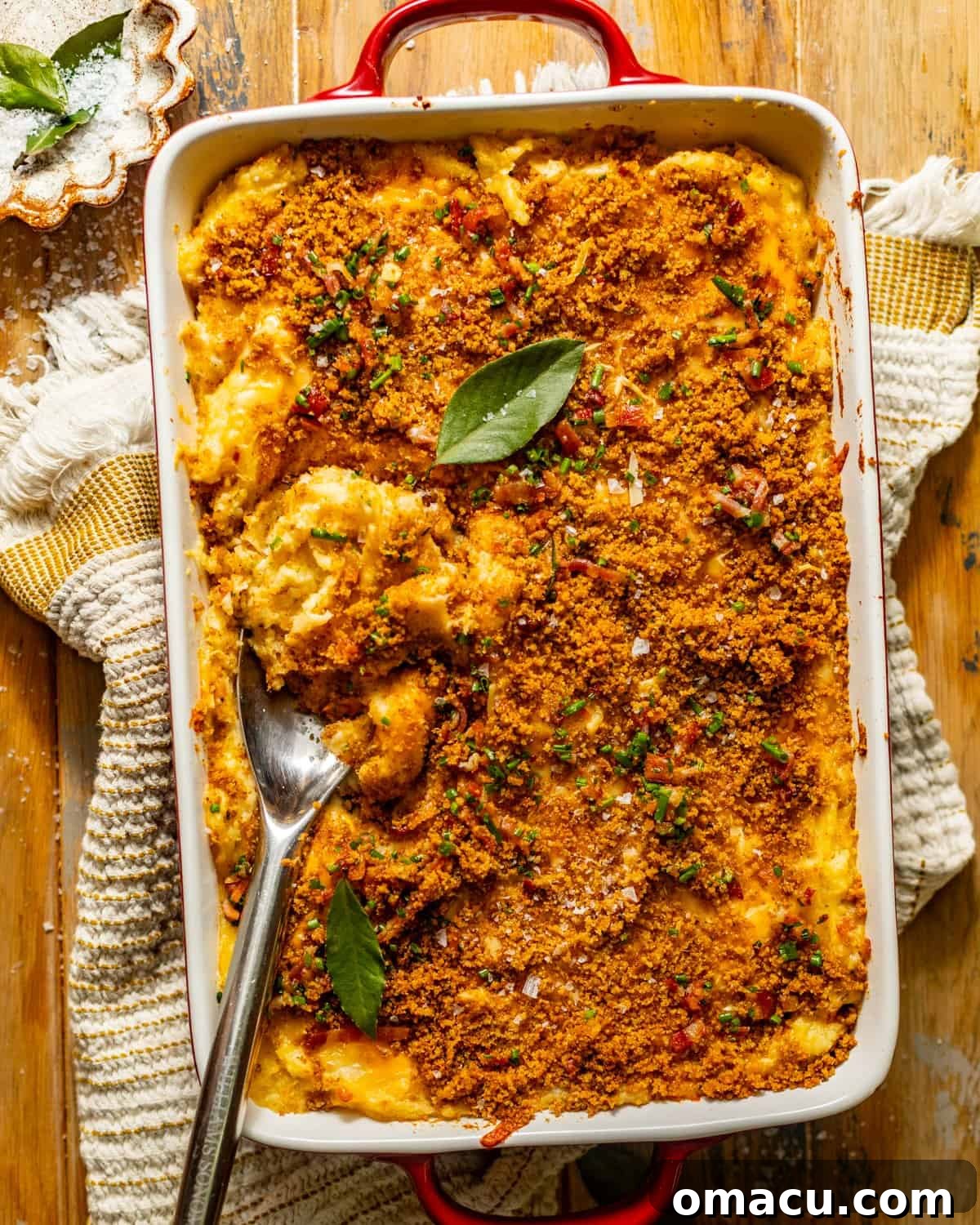 Overhead photo of a full baking dish of twice baked mashed potatoes, garnished with chives and bacon bits, ready for serving.