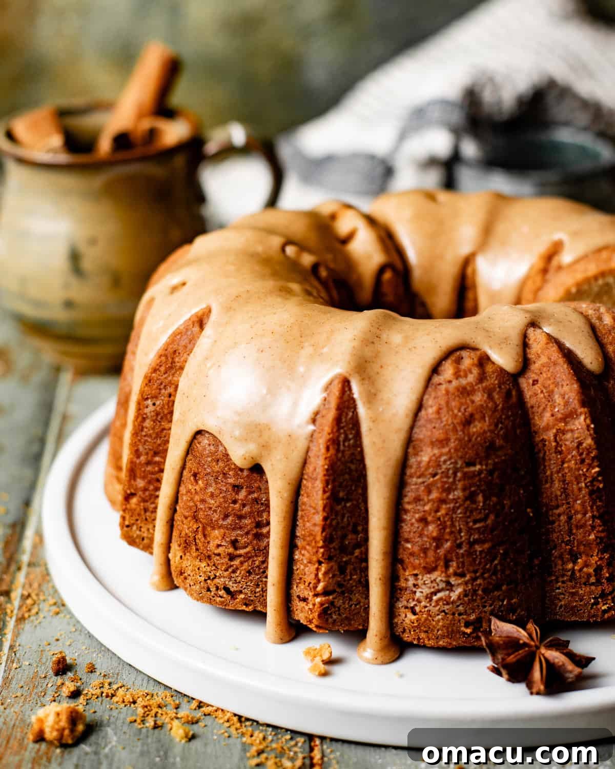 A beautifully glazed brown sugar pound cake on an elegant cake plate, drizzled with a rich toffee bourbon glaze.