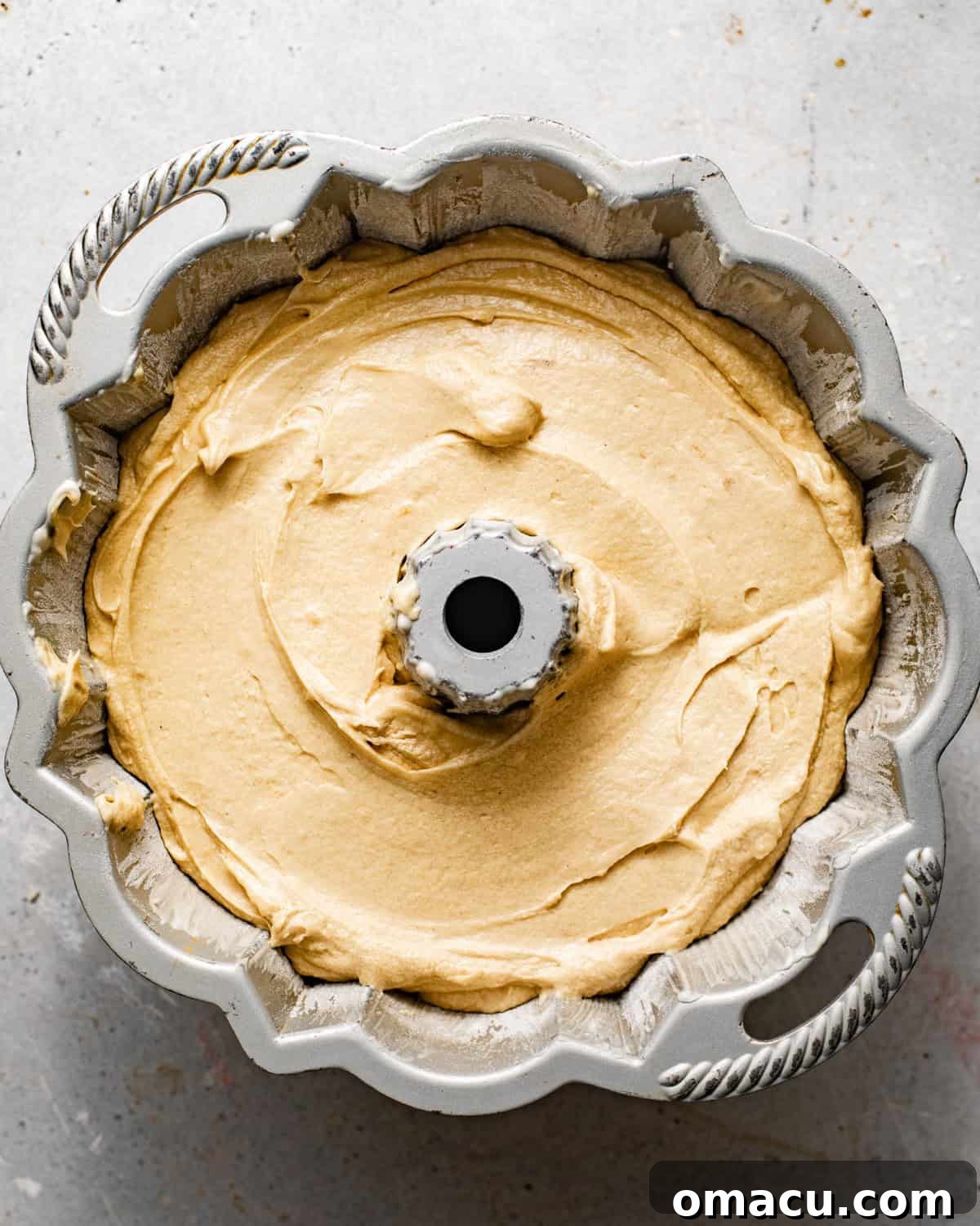 Brown sugar pound cake batter evenly poured into a greased bundt pan, ready for baking.