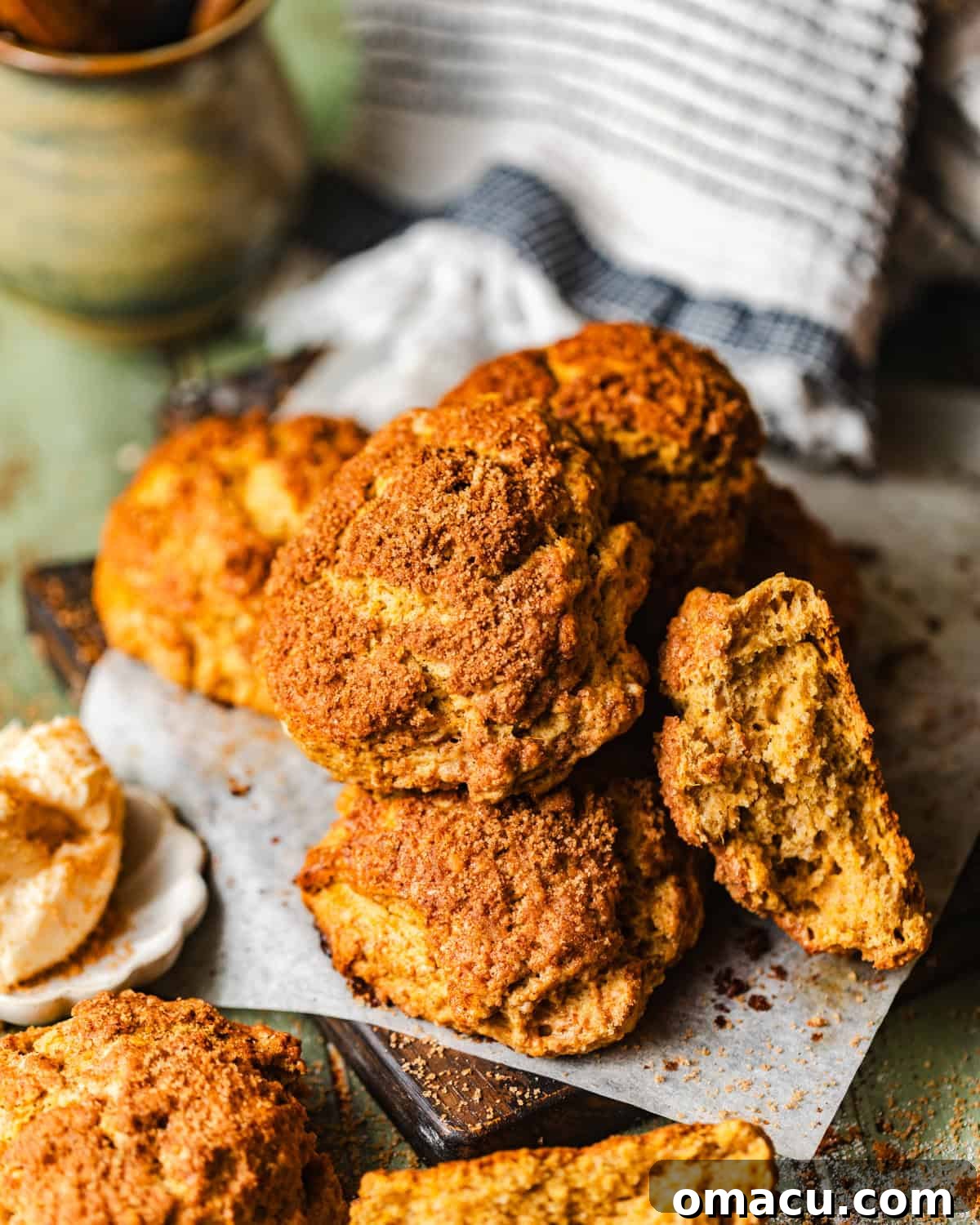 Stacked golden sweet potato biscuits on a rustic cutting board, ready to be enjoyed with honey butter.