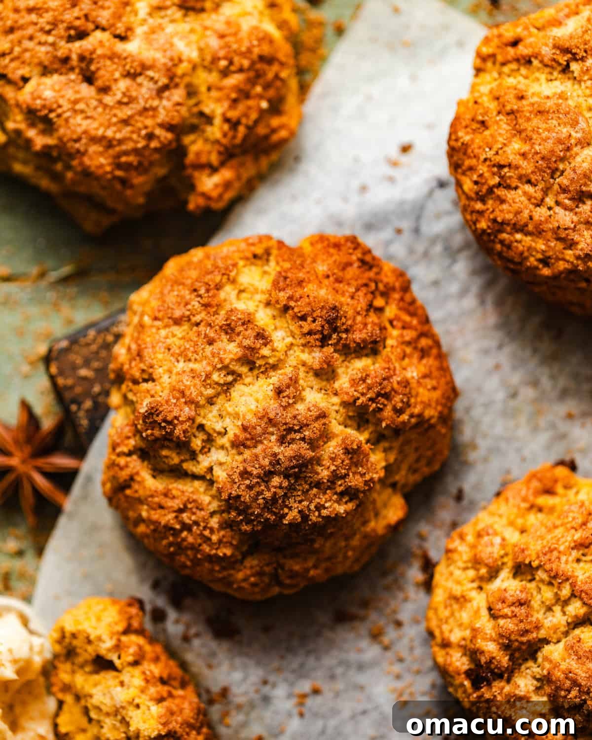 Close-up of baked sweet potato biscuits on a cutting board, showing their golden tops.