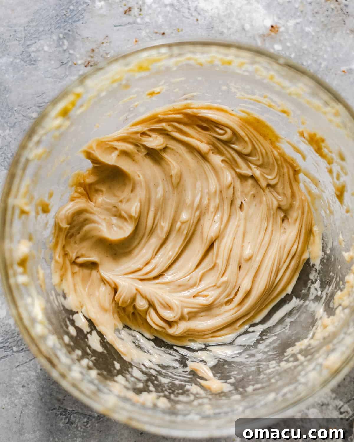 Bowl of freshly whipped honey butter with a spoon, ready to accompany warm biscuits.