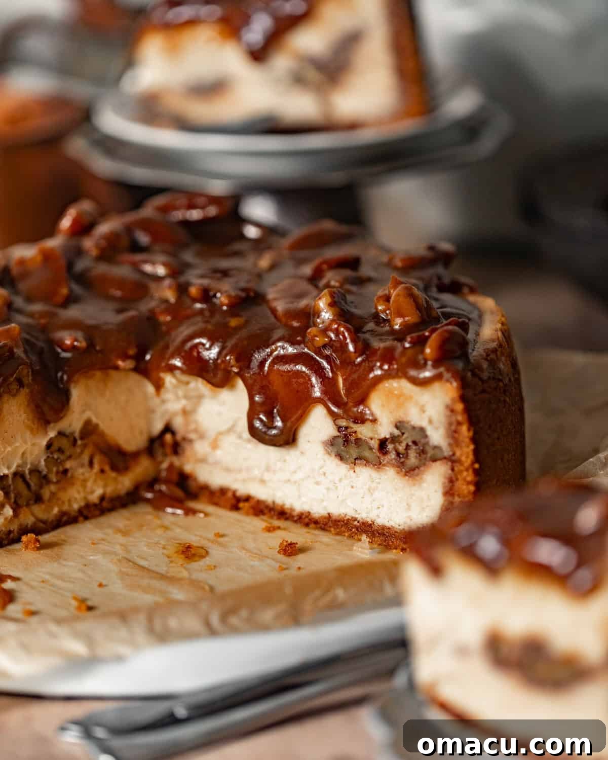 A glorious slice of pecan pie cheesecake presented on a serving dish with a spoon, ready to be enjoyed.
