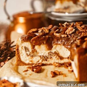 Sliced pecan pie cheesecake on a serving plate topped with pecan pie filling.