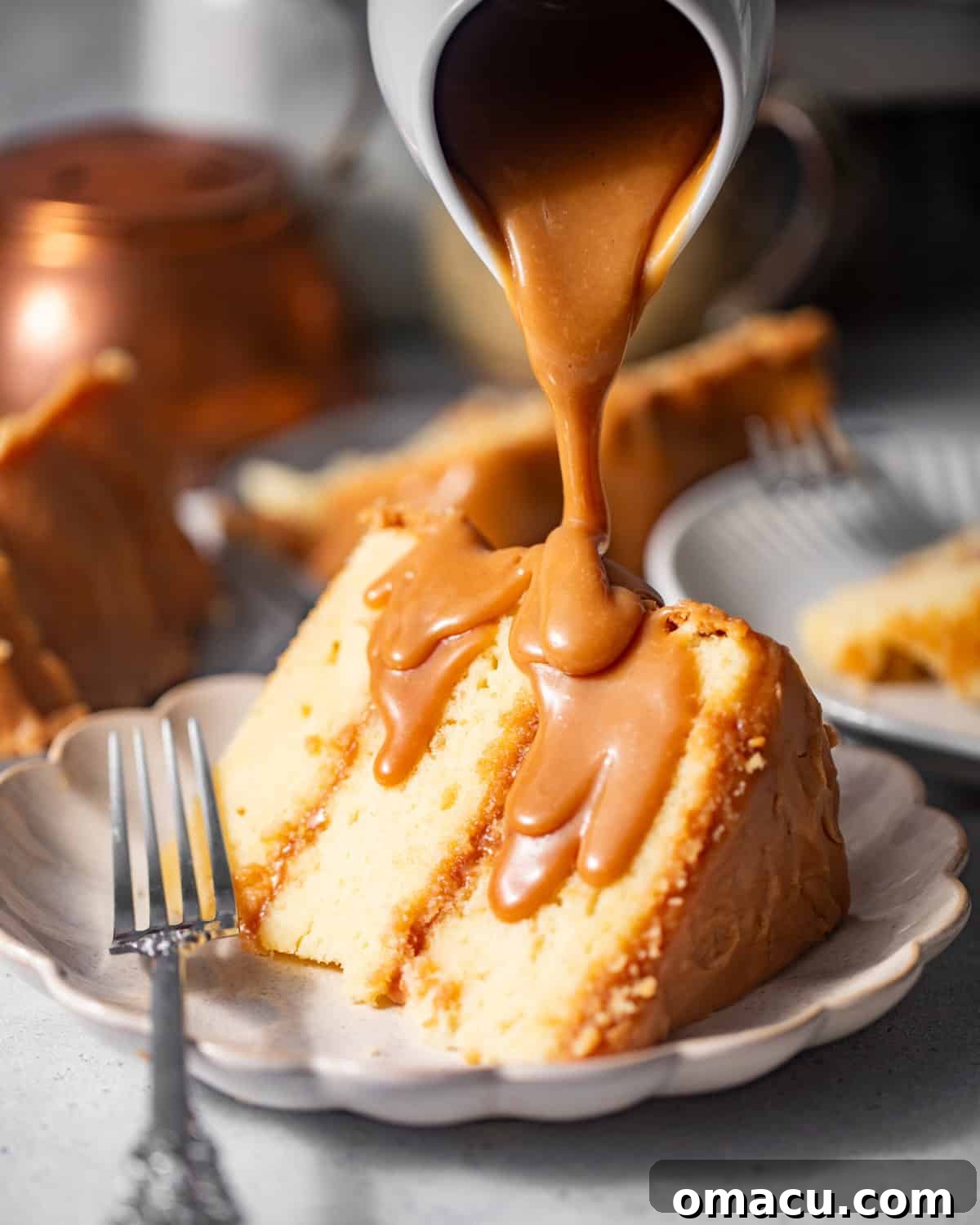 A slice of Southern Caramel Cake on a plate, generously drizzled with extra caramel sauce, showcasing its layers and rich frosting.