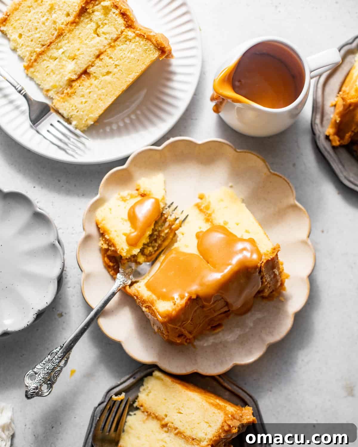 Several slices of caramel cake arranged on cake plates, each piece lavishly covered in a rich, glossy caramel frosting.