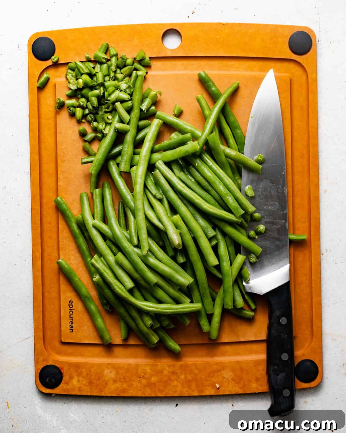 trimmed green beans on a cutting board. 