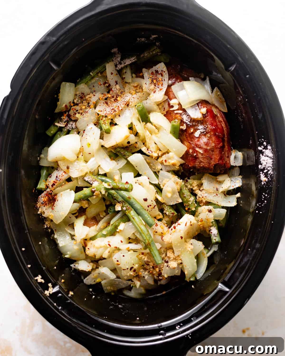slow cooker green beans in the slow cooker with smoked turkey, onions, broth, seasonings, and garlic.