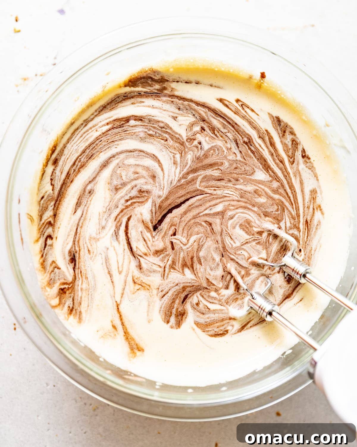 Whipped eggs and sugars with the melted chocolate mixture being added, creating a luxurious brownie batter.