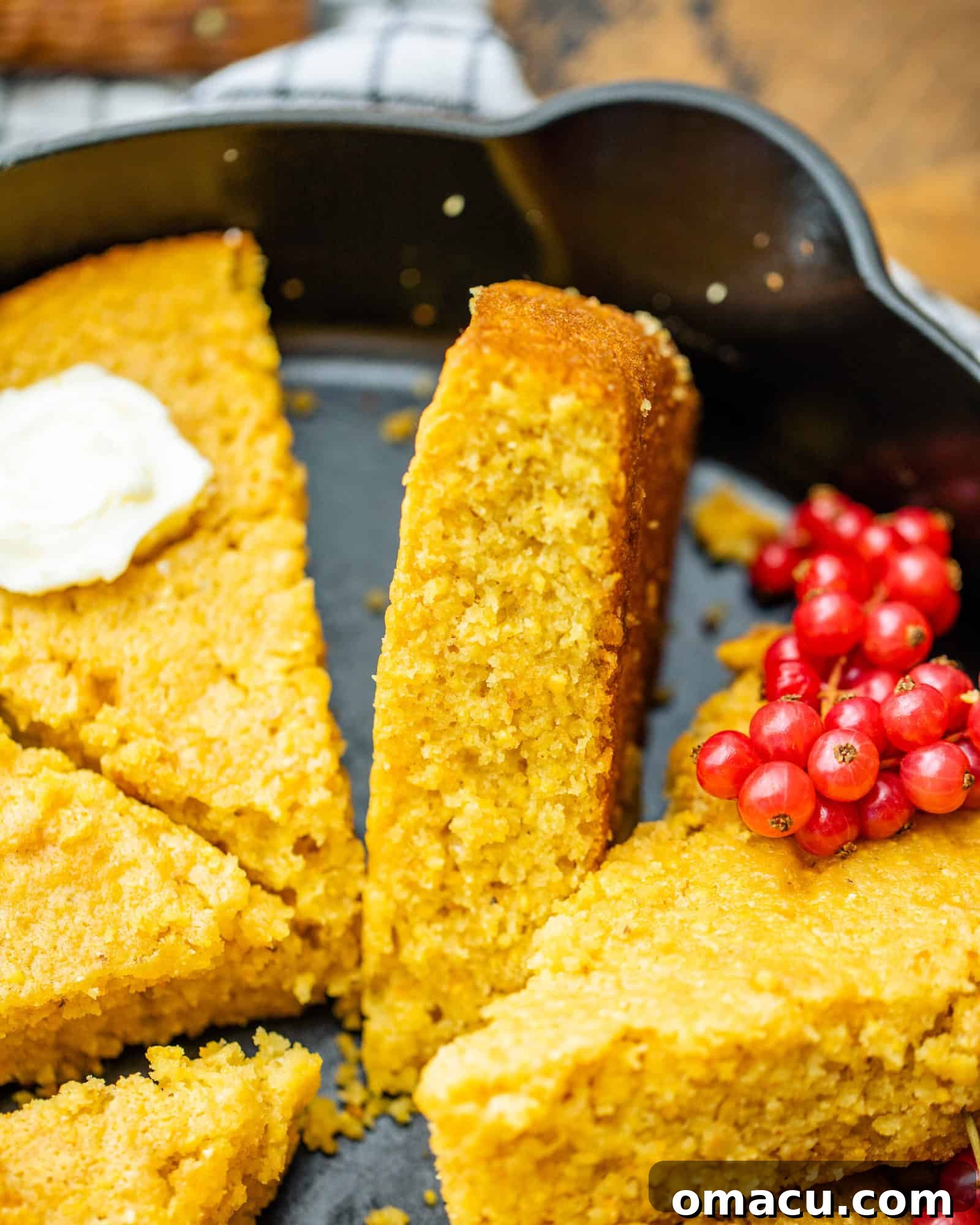 cast iron skillet cornbread sliced on a kitchen towel
