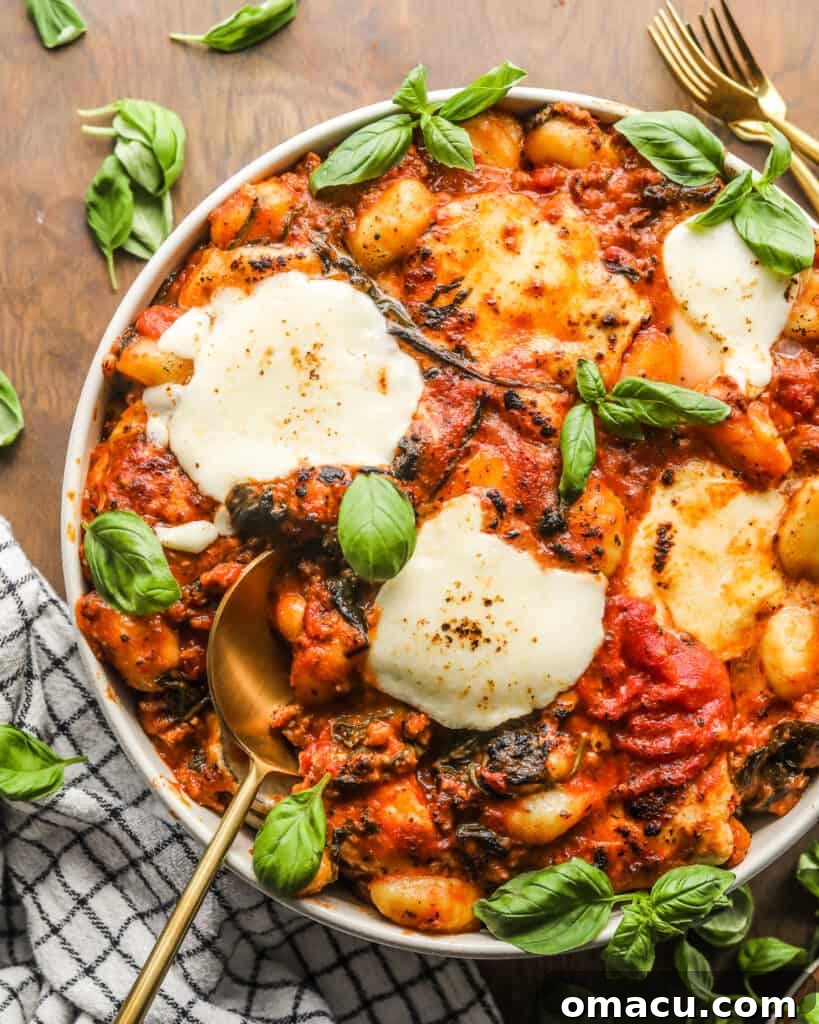 Sausage and Spinach Gnocchi Bake in a bowl garnished with fresh basil