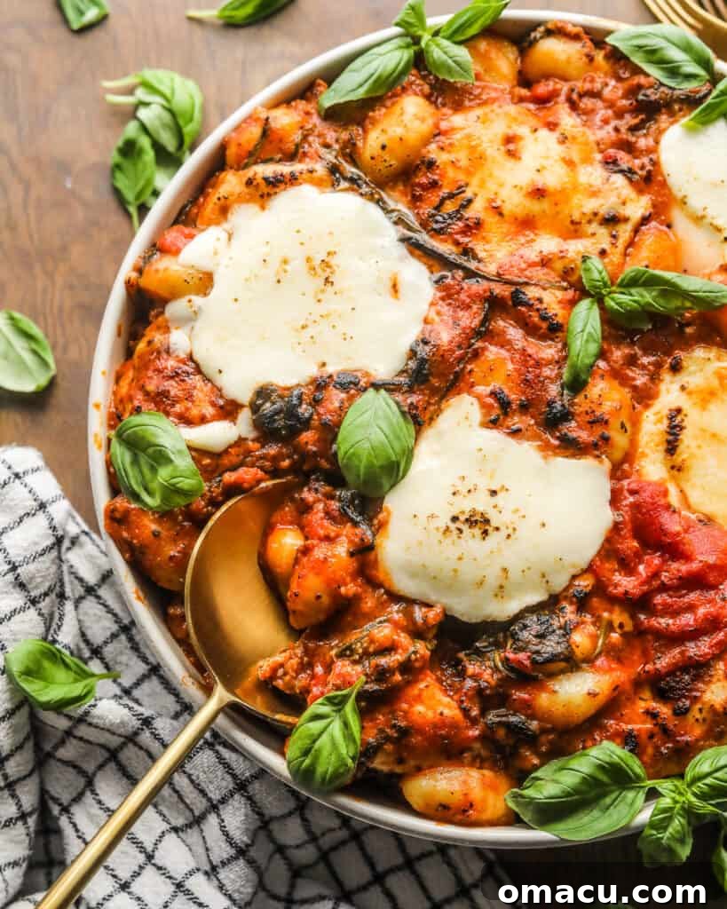 Close up shot of cooked Sausage and Spinach Gnocchi Bake in a casserole dish