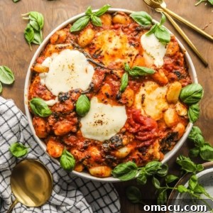 Sausage and Spinach Gnocchi Bake in a bowl garnished with basil