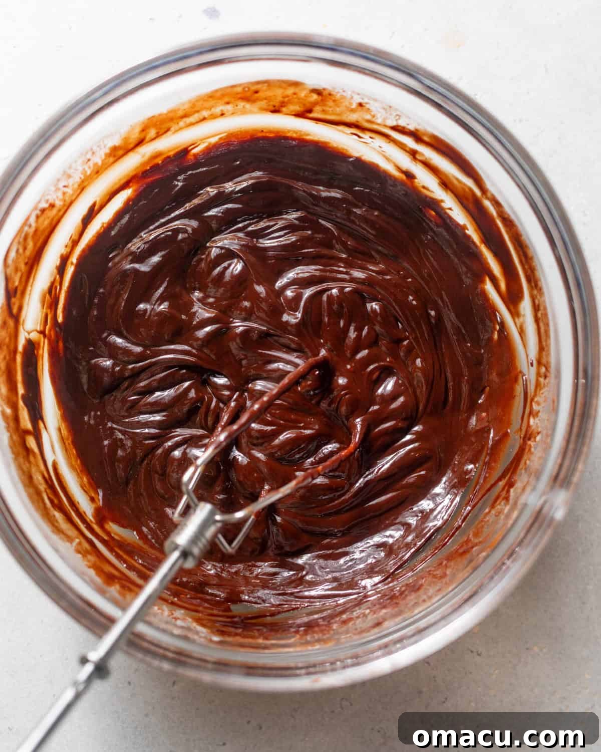 Semi-sweet chocolate chips and a portion of heavy cream gently melting together in a microwave-safe bowl, being stirred to form a smooth, rich chocolate mixture for the dip's base.