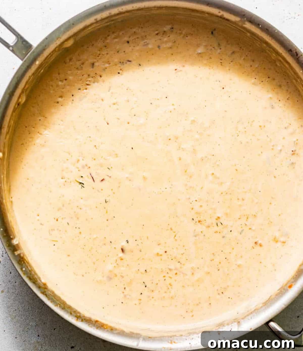 Creamy white wine sauce simmering in a pan after mussels have been removed.