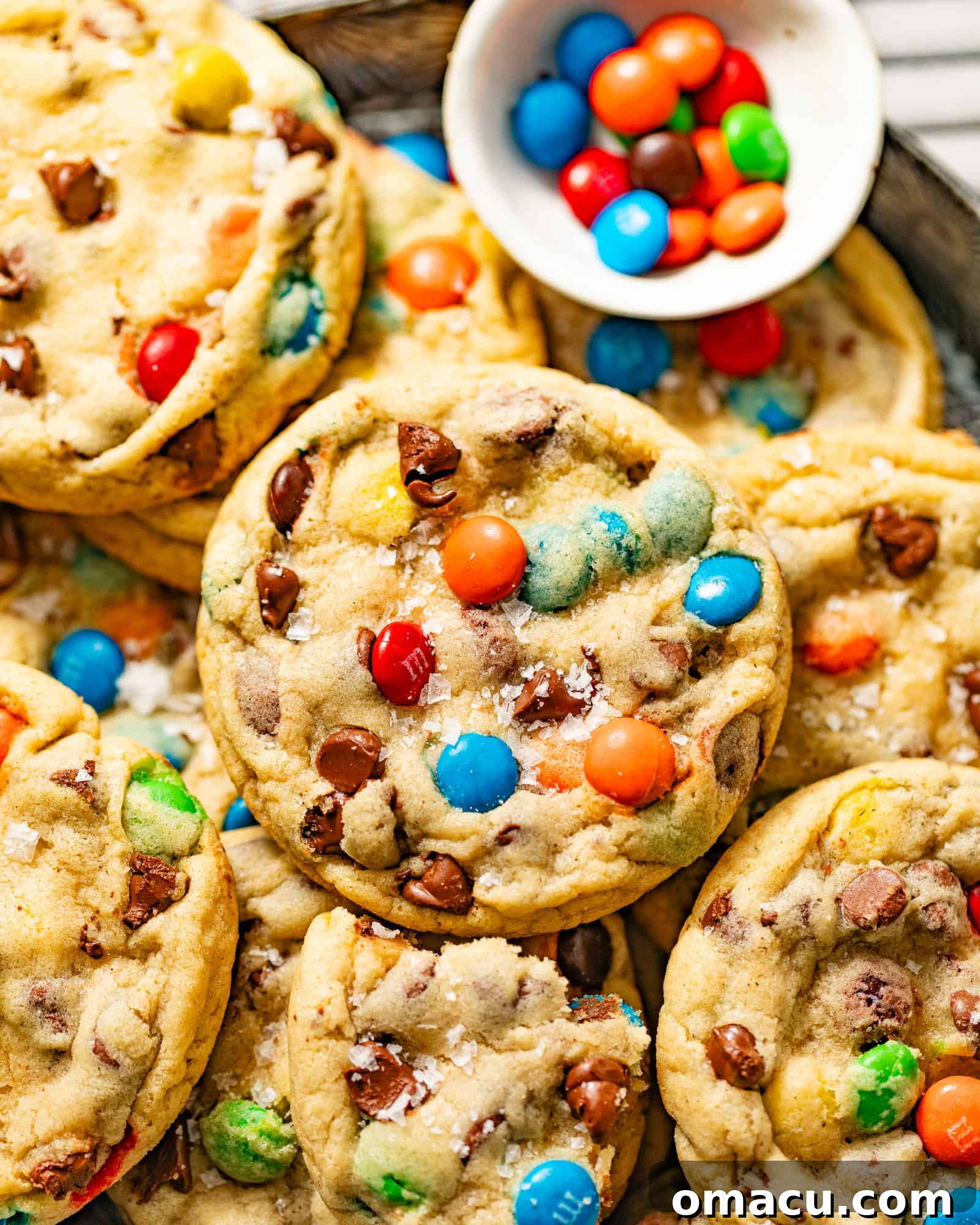 A bowl filled with freshly mixed M&M chocolate chip cookie dough, ready to be scooped and baked.