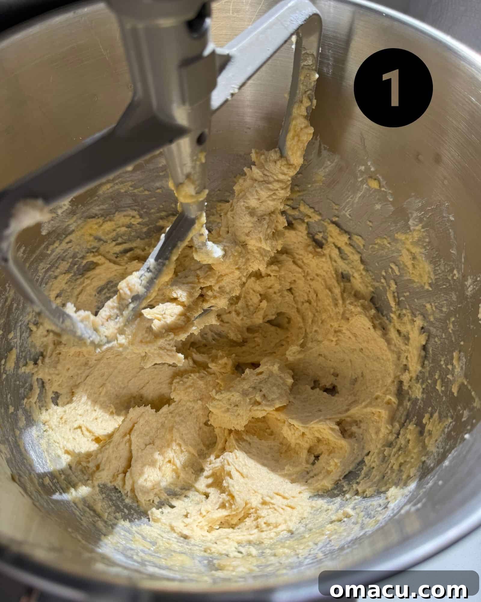 The creaming process of butter and sugar in a stand mixer, demonstrating the first step of cookie dough preparation.