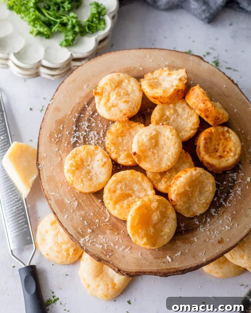 Pao De Queijo on a wooden cheese board with fresh herbs in the background