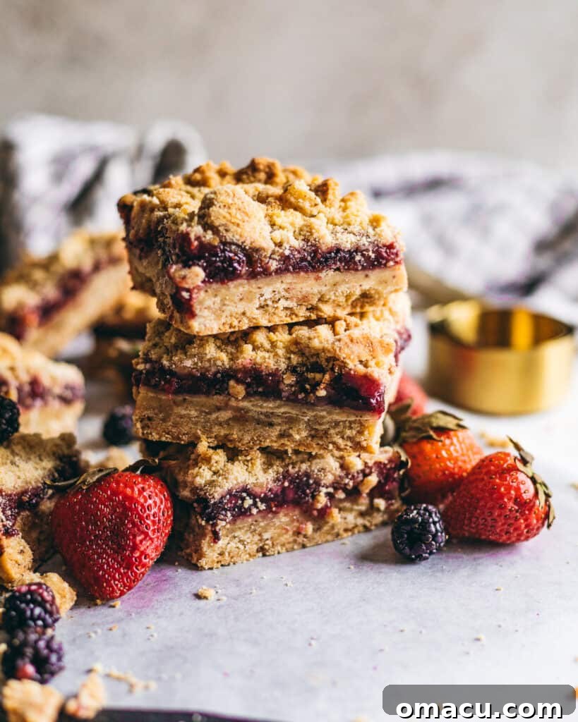 Stacked Brown Butter Mixed Berry Crumble Bars showcasing the golden crust, vibrant berry filling, and crumbly topping.