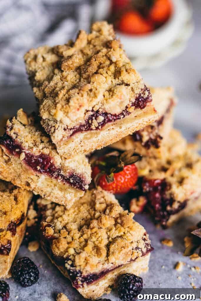A single Brown Butter Mixed Berry Crumble Bar highlighting the distinct layers of crust, filling, and crumble.