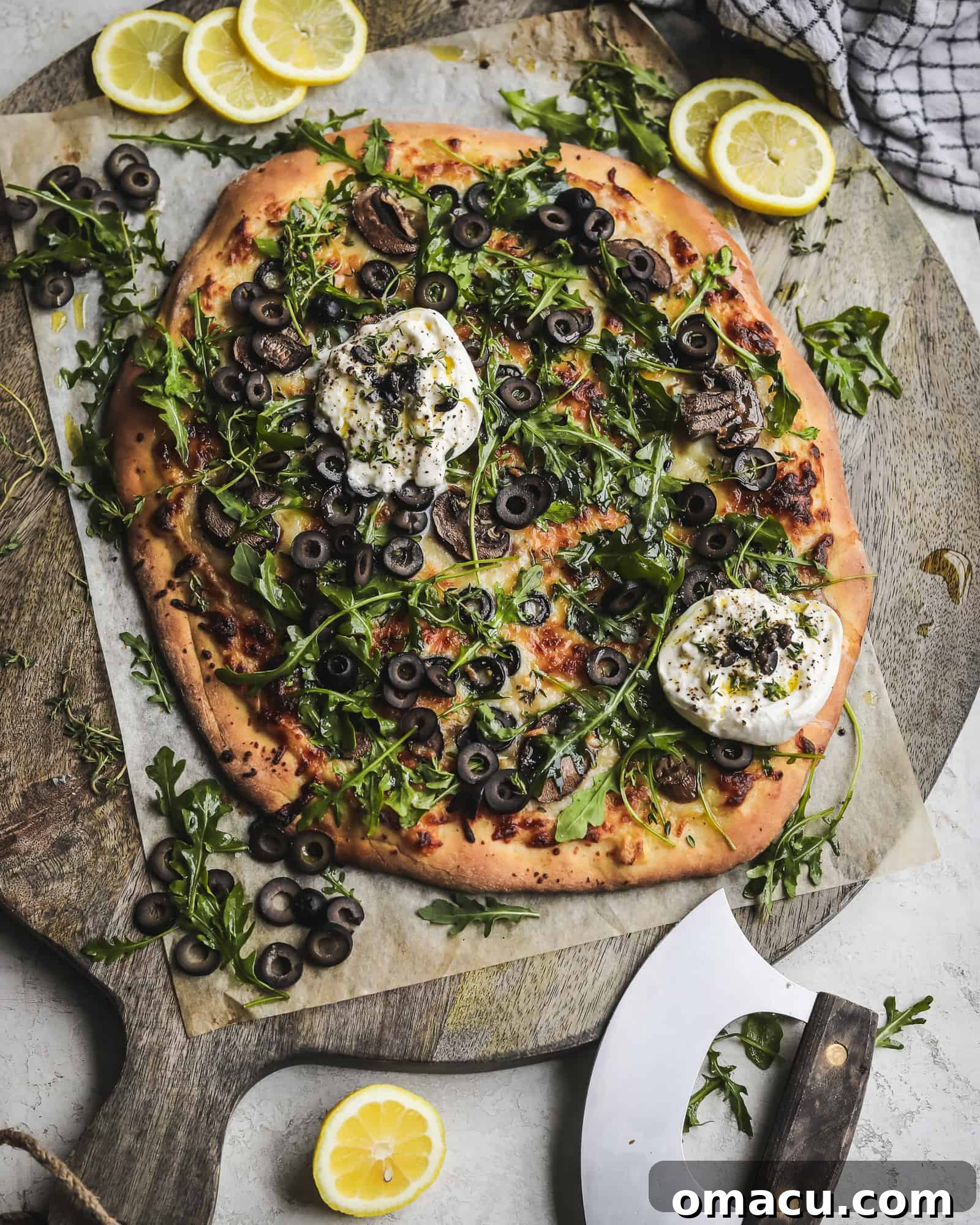 Sliced Black Olive Pizza with fresh arugula and burrata, ready to serve