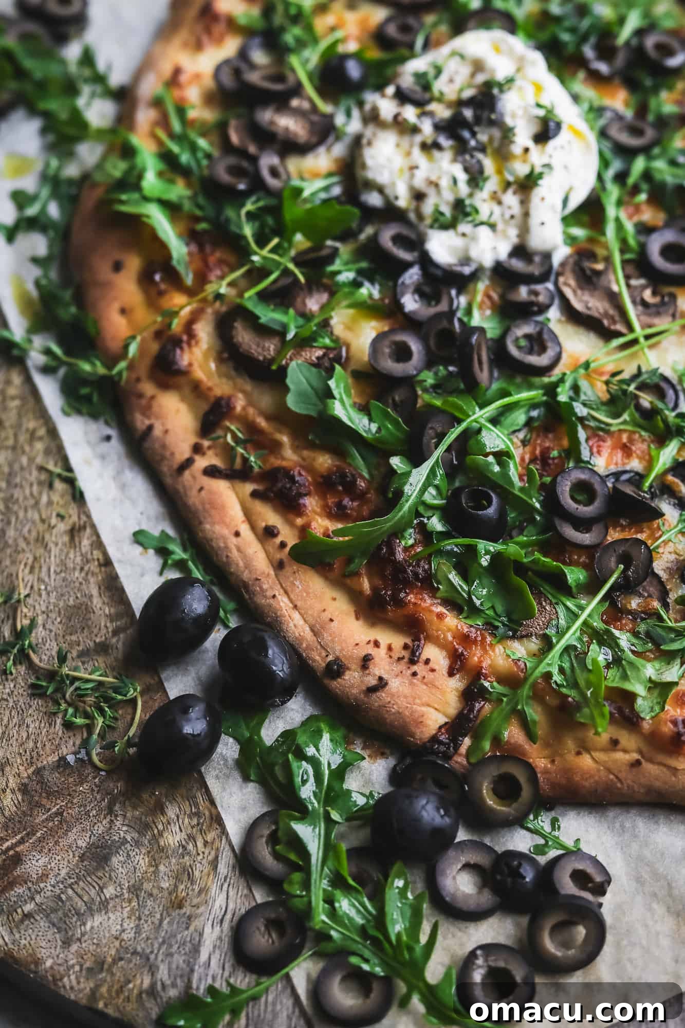 Close up shot focusing on the rich black olives and melted cheese on the pizza
