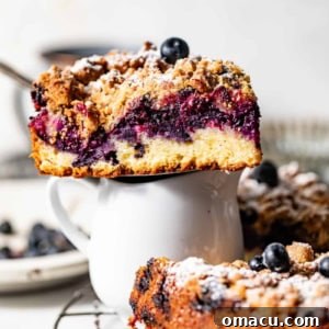 A slice of blueberry coffee cake sitting on top of a small cup.