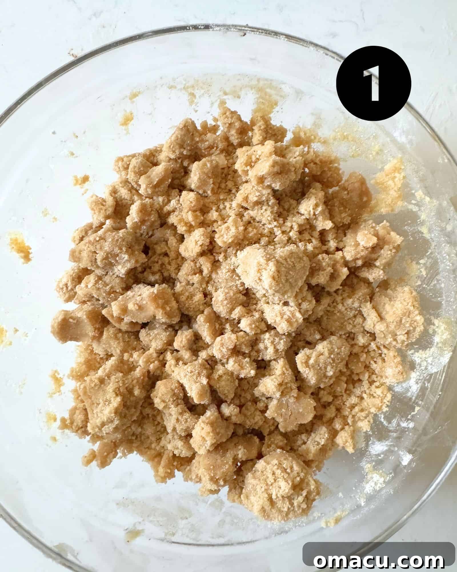 Close-up of the streusel topping mixture in a small bowl, showing the crumbly texture before chilling.