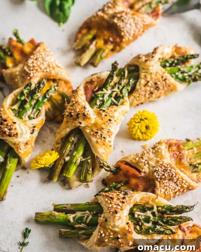 Freshly baked Asparagus and Prosciutto Puff Pastry Bundles on parchment paper, ready to serve