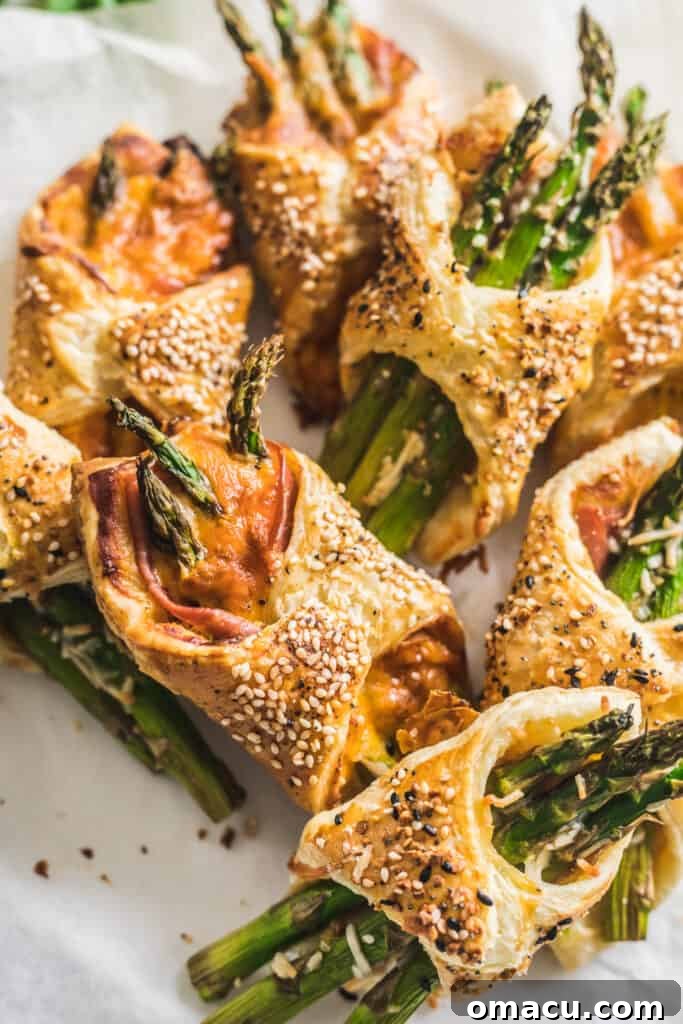 Several Asparagus and Prosciutto Puff Pastry Bundles cooling on parchment paper